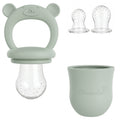 Groene siliconen fruitspeen met handvat en extra spenen, ideaal voor babyhapjes.